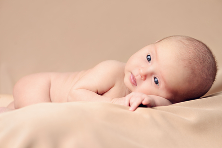 Portrait of a sweet newborn baby lying on a brown blanket. Baby care, Healthcare, pediatrics.の写真素材