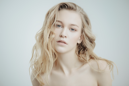 Portrait of a beautiful blonde woman with natural make-up. Beauty, haircare, cosmetics concept. Healthcare. White background.の写真素材