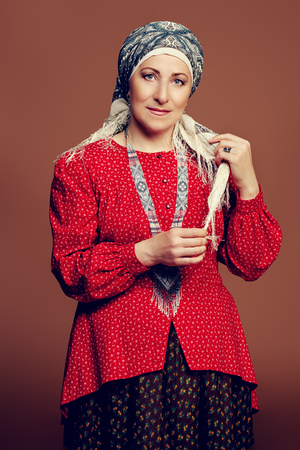 Mature woman in ethnic costume posing in studio.の写真素材