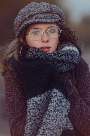 Cute teen girl in modern clothes posing outdoor. Warm autumn day. Seasonal autumn and winter fashion.の写真素材