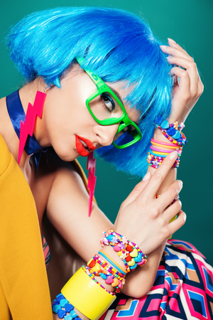 Portrait of a fashion girl with blue hair wearing bright summer clothes over blue background. Beauty, fashion concept.  Pin-up style.の写真素材