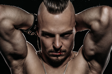 Fight club, MMA. Portrait of a bad guy fighter demonstrating his muscles and strength. Rocker, punk.の写真素材
