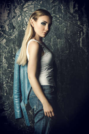Portrait of a beautiful girl in casual clothes over grunge background. Beauty, fashion concept. Studio shot.の写真素材
