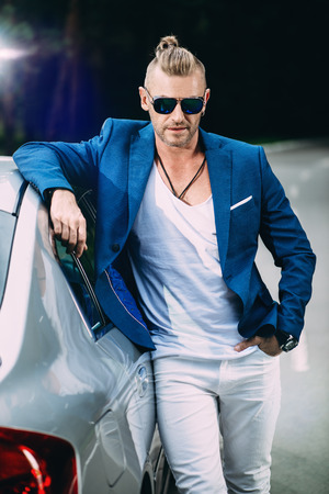 Modern mature man standing by his car.の写真素材