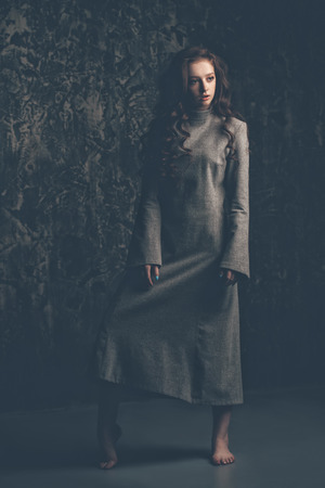 Modern  fifteen-year-old girl with long curly red hair is dancing in the studio. Beauty, fashion. Vogue dance.の写真素材