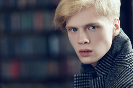 Close-up portrait of a fair-haired guy in checkered coat in the room. Fashion shot. Men's beauty, fashion.の写真素材