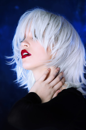Close-up portrait of a beautiful blonde woman with bright make-up over dark background. Beauty, fashion concept. Make-up and cosmetics. Studio shot.の写真素材