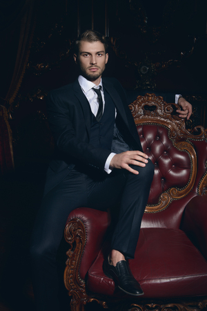 Imposing well dressed man in a luxurious apartments with classic interior. Luxury. Men's beauty, fashion.の写真素材