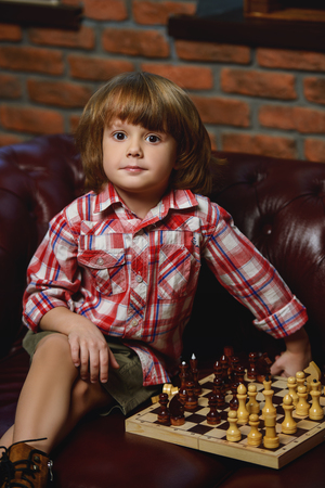 Little boy playing chess at home. Games and activities for children. Family concept.の写真素材