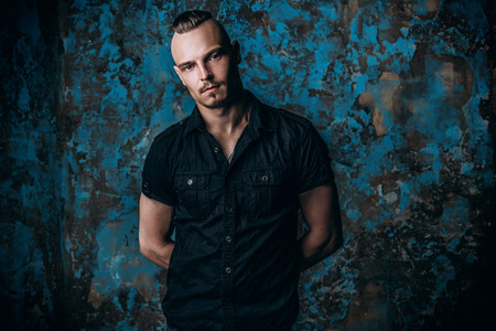 Portrait of a punk man in black shirt. Fashion, subculture. Studio shot.の写真素材
