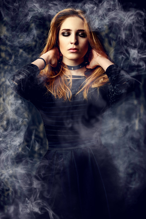 Magnificent woman in black gothic dress over grunge background. Fashion. Gothic style.の写真素材