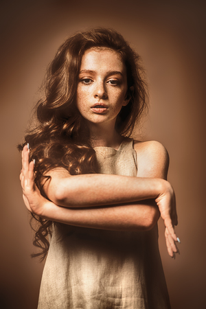 Modern  fifteen-year-old girl with long curly red hair is dancing in the studio. Beauty, fashion. Vogue dance.の写真素材