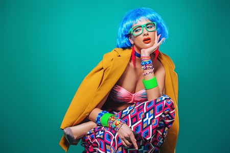 Portrait of a fashion girl with blue hair wearing bright summer clothes over blue background. Beauty, fashion concept.  Pin-up style.の写真素材