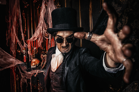 Halloween. Scary frightening man in black holds out his hand. Old abandoned castle. The Dark Lord. Vampire man.の写真素材