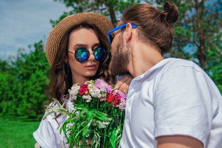 Happy young people in love in the park on a sunny summer day. Summer holidays. Love concept.