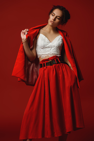 Beautiful girl with pink hair wearing bright clothes over red background. Bright style, fashion.の写真素材