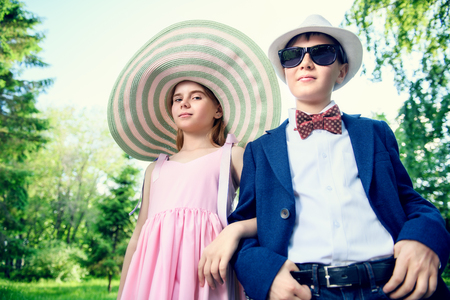 Elegant beautiful girl and boy in a summer park. Children's fashion. Happy summer holidays.の写真素材