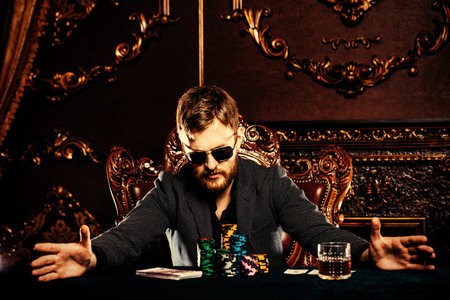 A wealthy mature man playing poker in a casino. Gambling, playing roulette. Rich and luxury.