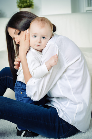 Happy young mother playing with her small baby. Family concept. Healthcare, pediatrics.の写真素材