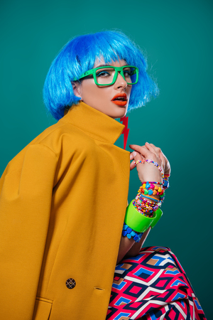 Portrait of a fashion girl with blue hair wearing bright summer clothes over blue background. Beauty, fashion concept.  Pin-up style.の写真素材