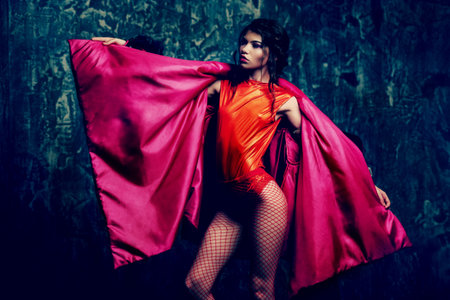 Vogue shot of a female model posing at studio. Fashion collection. Portrait over grunge background.