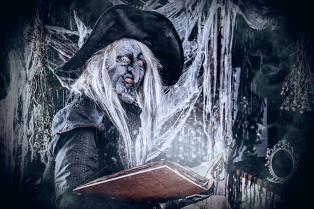 A witch checking the book with spells. Halloween. Horror movie.の写真素材