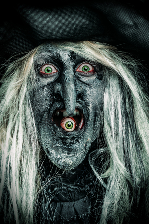 A wizard is eating an eye. Halloween. Horror film.の写真素材