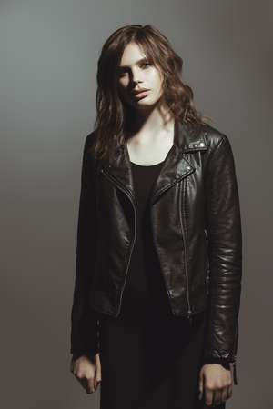 Portrait of a stylish fashion female model in a leather jacket. Beauty, fashion concept. Studio shot.の写真素材