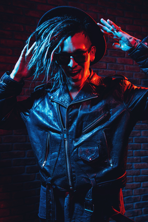 Portrait of a crazy disco man with dreadlocks. Party, disco. Colorful light.の写真素材