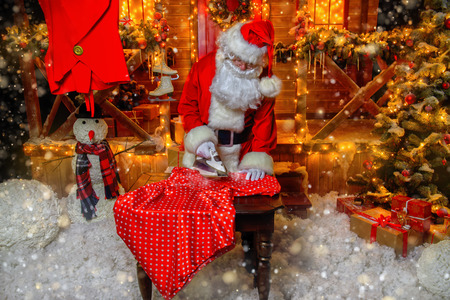 Portrait of Santa Claus ironing cloth. Christmas and New Year concept.の写真素材