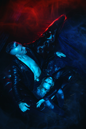 A vampire woman is lying on the legs of her lover and partner. Classic style. Beauty, fashion. Halloween celebration.の写真素材