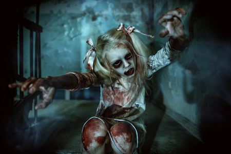 Scary girl is sitting on the stairs. Halloween. Horror movie.の写真素材