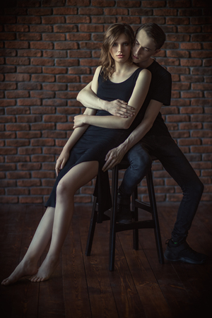 Beautiful young couple in love posing near a brick wall. Beauty, fashion.の写真素材