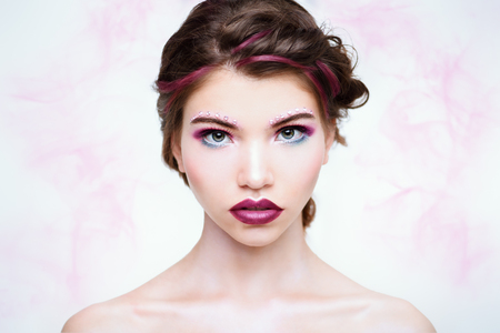 Make-up and cosmetics concept. Beauty portrait of a sexual woman with bright make-up. White background.の写真素材