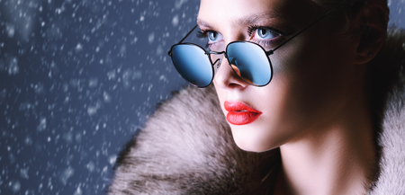 A close-up of a confident and beautiful fair-haired lady in sunglasses. Beauty, winter fashion.の写真素材