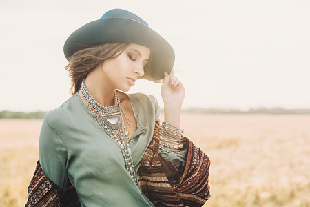 Romantic young woman on a background of a golden wheaten field. Beauty, fashion.の写真素材