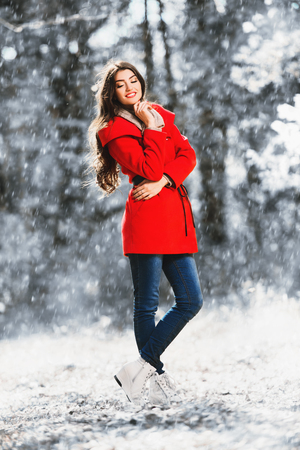 A full length portrait of a beautiful young woman in an autumn forest. Lifestyle, autumn fashion, beauty.の写真素材