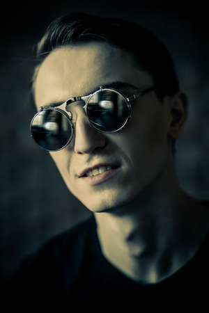Close-up portrait of a handsome pensive young man in a room. Men's beauty and health.の写真素材