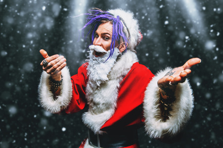 Portrait of a cool punk Santa Claus with bright dreadlocks over black background.の写真素材