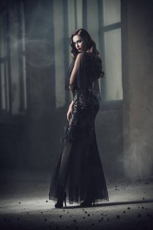 A beautiful brunette lady is in ruins. Evening dress. Fashion, beauty.の写真素材