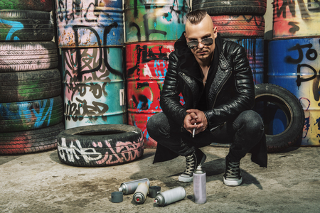 Portrait of a punk man on the street with cigarette at backyard. Fashion, subculture.の写真素材