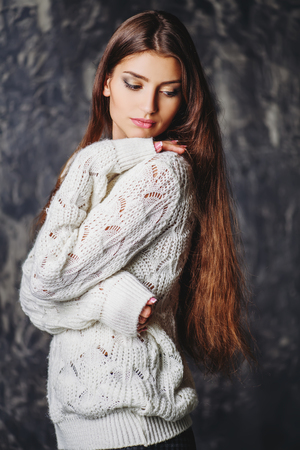 A portrait of beautiful Lady in a white sweater over the grunge background. Natural pure beauty. Make-up concept.の写真素材