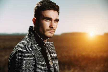 A portrait of a handsome man in countryside. Autumn fashion for men. Freedom, lifestyle.の写真素材