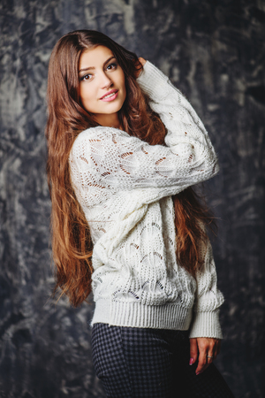 A portrait of beautiful Lady in a white sweater over the grunge background. Natural pure beauty. Make-up concept.の写真素材