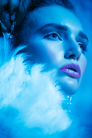 A close up portrait of a cold beautiful lady posing in the studio over the blue background. Beauty,cosmetics, hairstyle.の写真素材