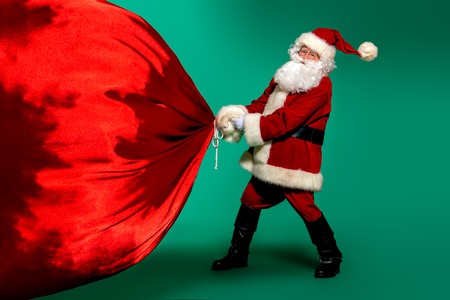 A portrait of Santa Claus with a huge gift bag. Merry Christmas and Happy New Year!の写真素材