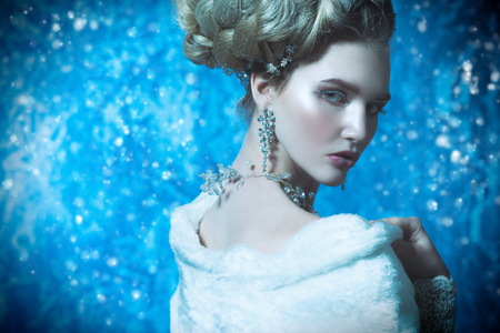 A close up portrait of a cold beautiful lady posing in the studio over the blue background. Beauty,cosmetics, hairstyle.の写真素材