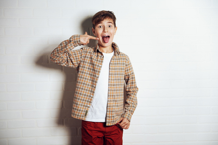 A portrait of an emotional young boy in casual clothes. Fashion for male teenagers.の写真素材