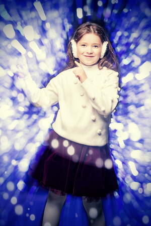 A portrait of a cute girl over a shining background. Christmas, New Year party.の写真素材