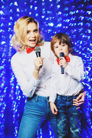 Portrait of a happy mom with her little son wearing white shirts and bow ties. Merry Christmas and Happy New Year.の写真素材
